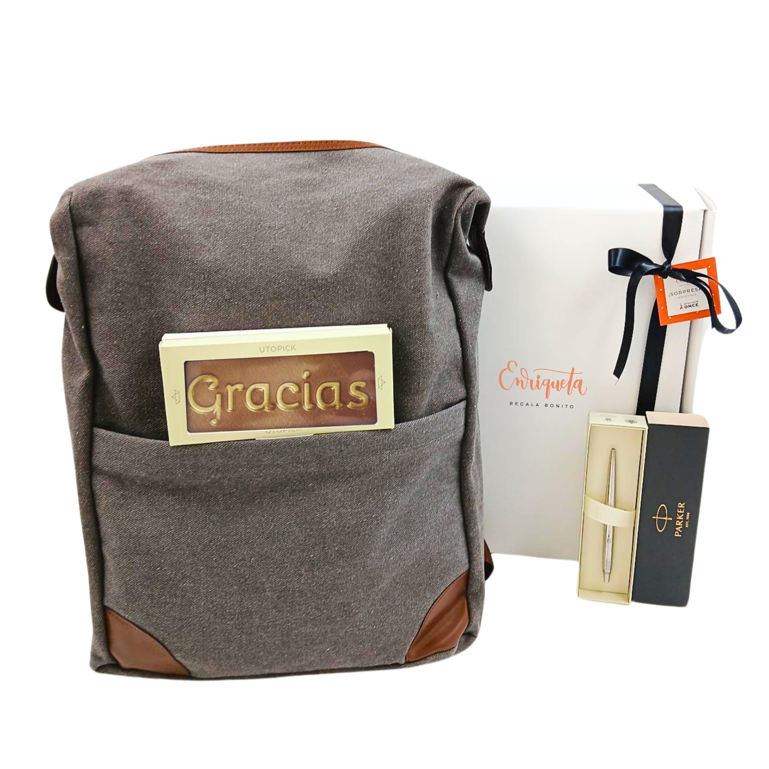 Caja blanca de regalo con lazo negro , mochila grande color gris, un boligrafo plateado y una tableta de chocolate con la palabra gracias image number null